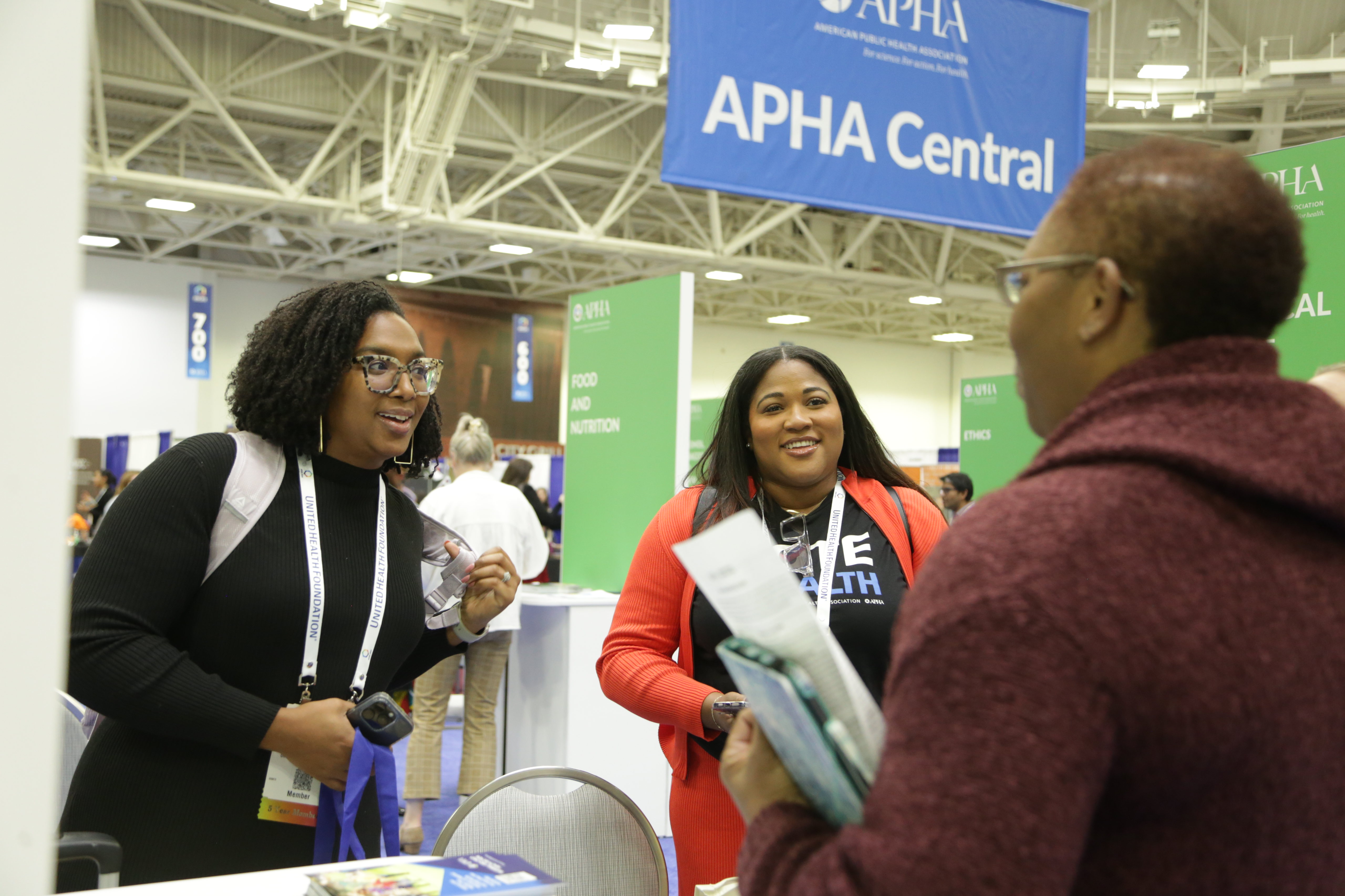 Members at the APHA 2024 meeting talking at a booth